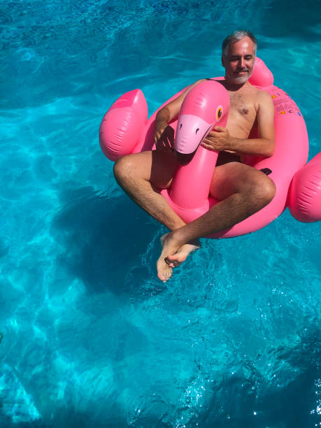 istock Smiling Mature Man Relaxing on Pool Raft in Swimming Pool 1263662763