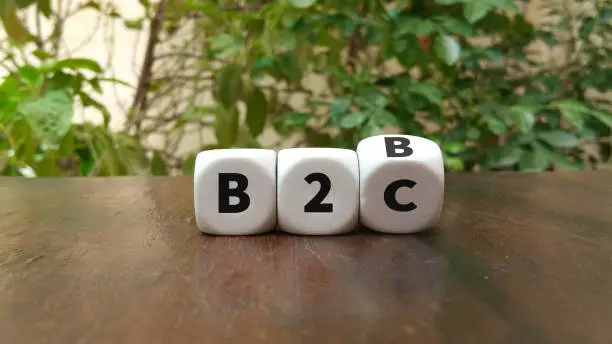 Business to Business or Busness to Consumer Hand turns a dice and changes the expression B2B to B2C or vice versa