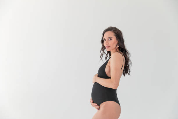bella donna incinta in un body nero. minimalismo - women smiling body cheerful foto e immagini stock