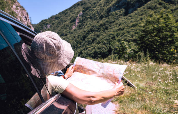 istock woman in car looking at map 1263668597