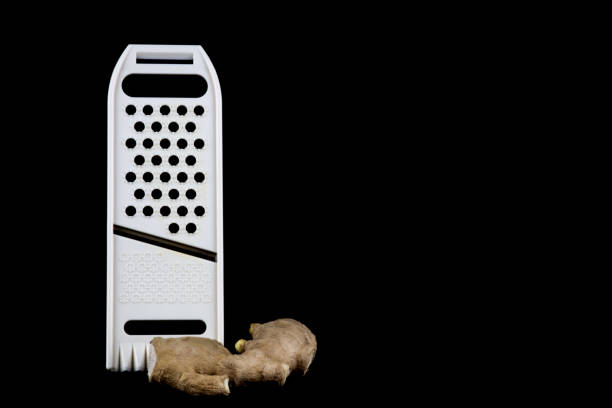 Mandolin food slicer with fresh ginger isolated on a black background