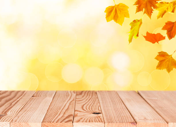 istock Wood table top on the autumn background with maple leaves 1263671209