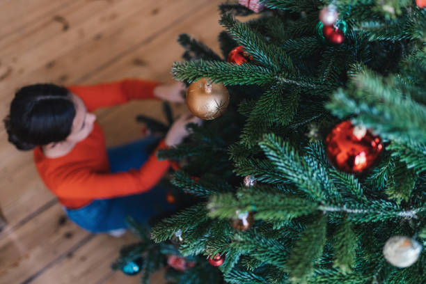 istock teenage girl decorating christmas tree 1263672929