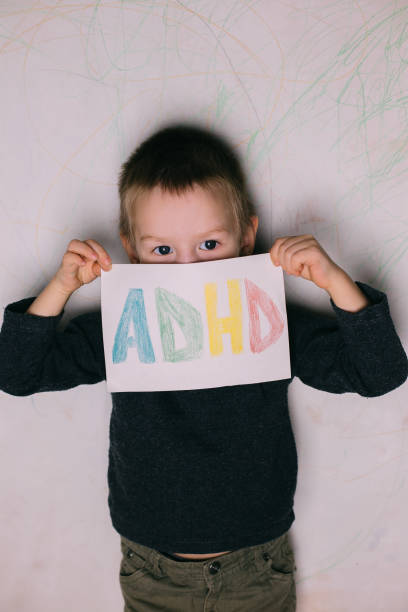 istock Young boy hold ADHD text written on sheet of paper 1263672931