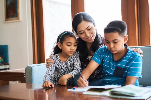 istock Smiling mother helping her son with his homework 1263672938