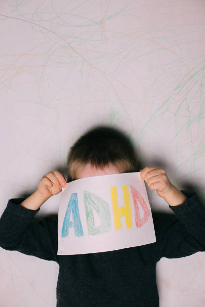 istock Young boy hold ADHD text written on sheet of paper 1263672996