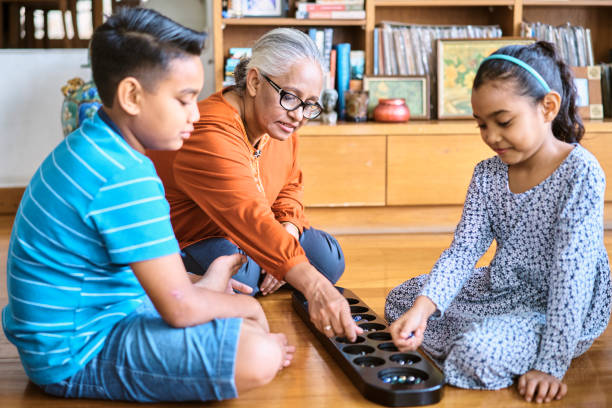 abuela jugando con sus nietos en casa - traditional games fotografías e imágenes de stock