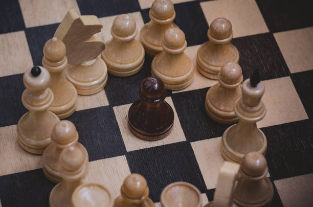 istock Chess game with black and white wooden chips on wooden board. 1263681934