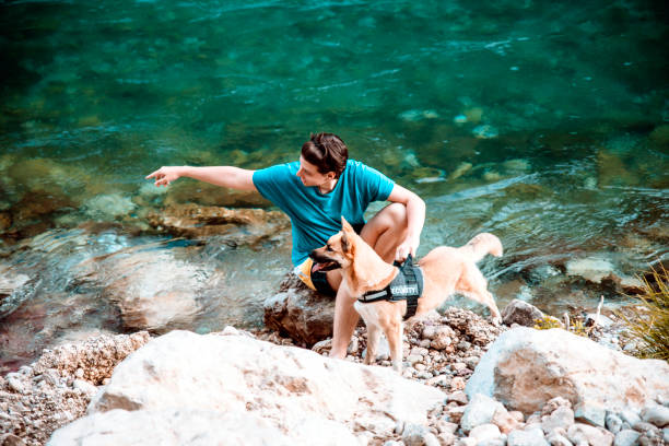 istock Guy Walking by the River with his service Dog 1263682860