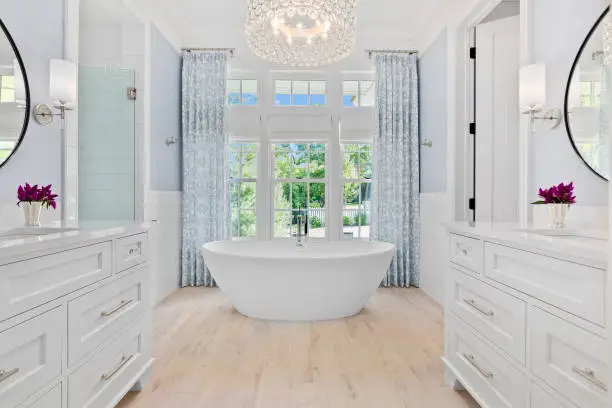 Symmetrical view of bathtub with his and hers vanities on each side