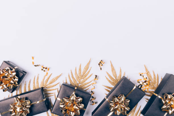 istock Festive flat lay composition black gifts boxes with golden palm leaves 1263684796