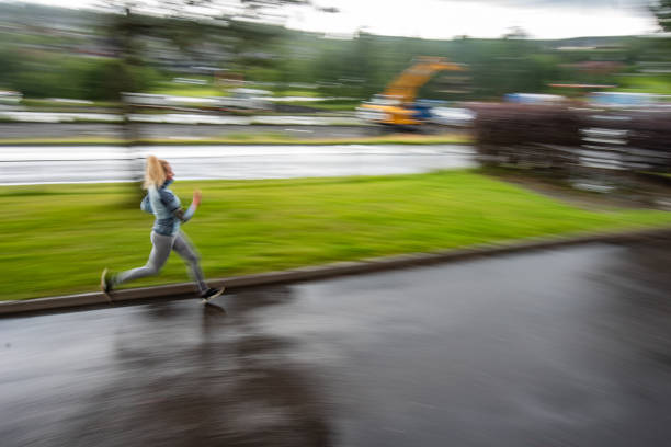 Beautiful young woman training running on a rainy day.