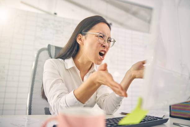 istock Emotional brunette woman shouting at her computer 1263689355