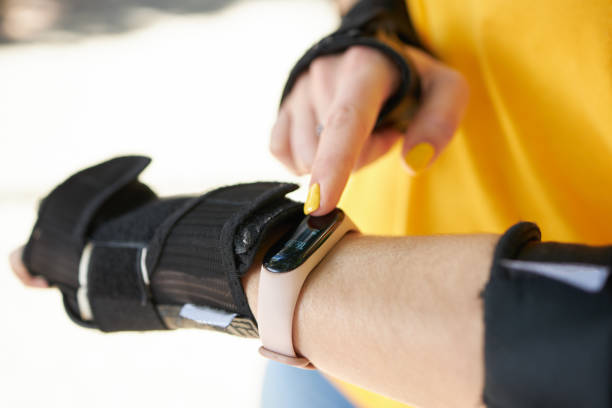 istock female person touching smart watch or fitness tracker while roller skating leisure activity. close up. sunny day. girl wearing hand protection for sport exercises. 1263690200