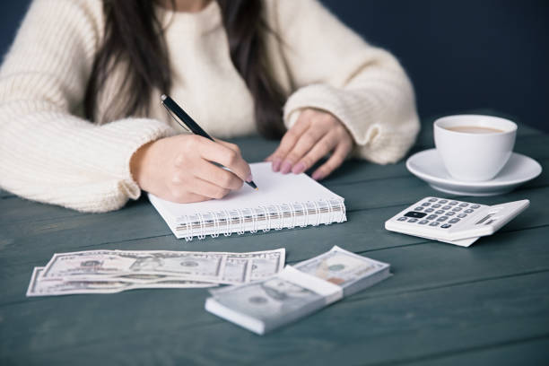 istock woman hand notepad with money 1263690587