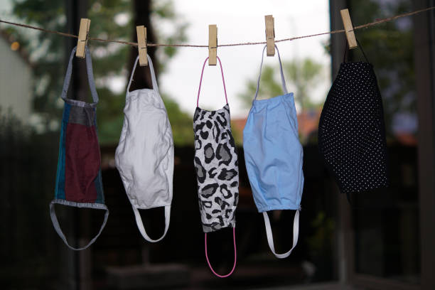 istock Five community masks drying on a rope 1263693522