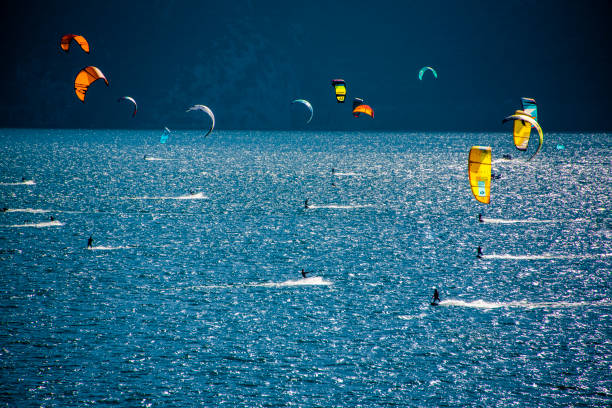 surfing in the lake two kitesurfing in the early morning on Lake Garda in Limone sul Garda, Brescia, Italy kiteboard stock pictures, royalty-free photos & images