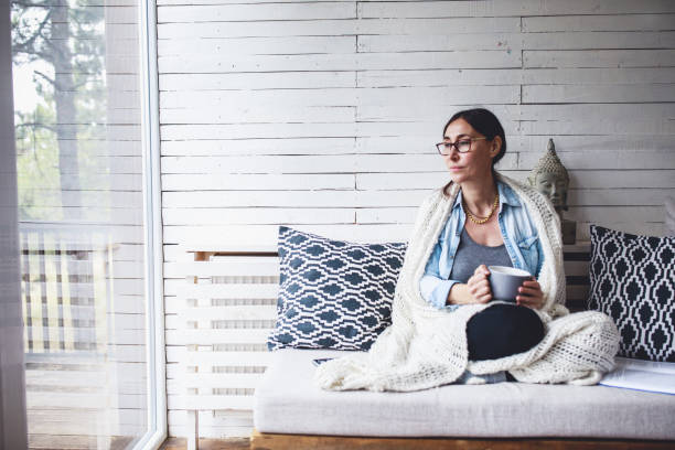 istock Woman sitting comfortable and looking through the window 1263694698
