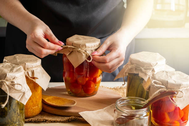 女性の缶と漬け野菜。トマトの発酵プロセス。健康的なエコフード。 - canning ストックフォトと画像
