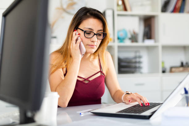 istock Latina woman using phone at office 1263697400