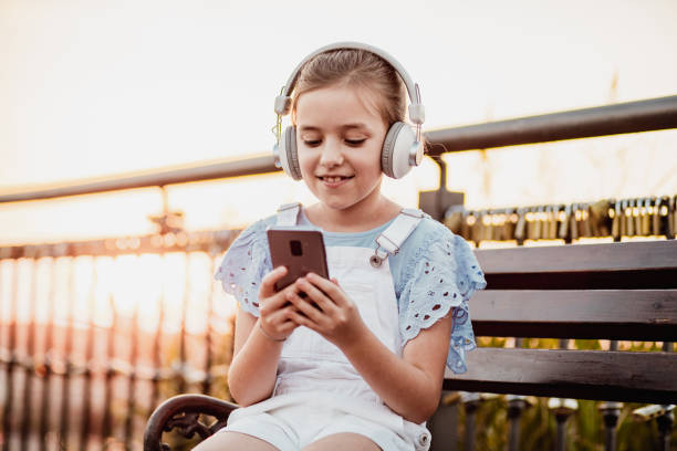 istock Little girl is using mobile phone after school 1263700943