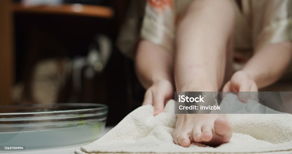 Woman taking self pedicure at home Foot Stock Photo