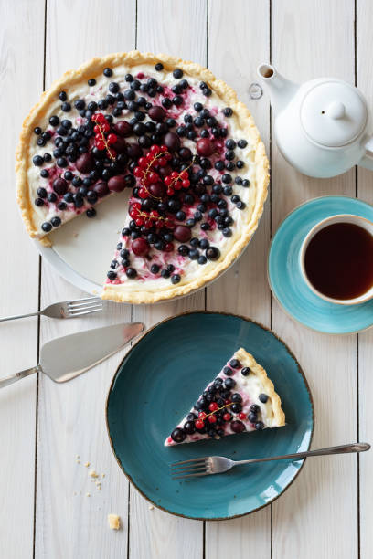 istock Blueberry open pie on blue plate with cup of black tea and white tea pot on bright painted wood background 1263701193