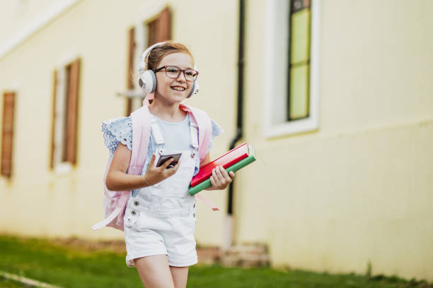 Little girl is using mobile phone after school