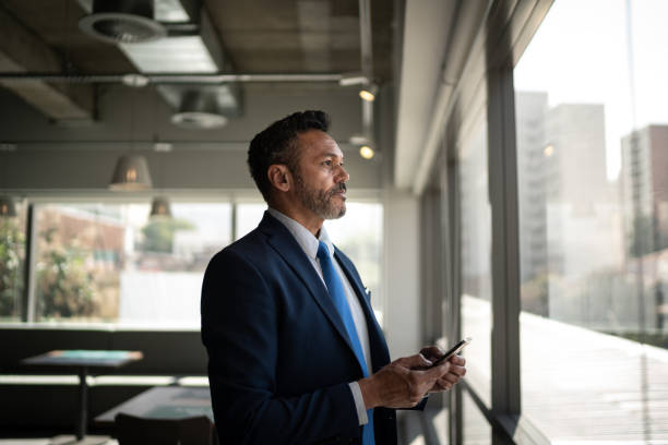 istock Serious businessman looking through the window 1263701306