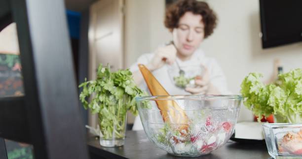 istock Woman is making a portion of fresh salad for herself 1263702149