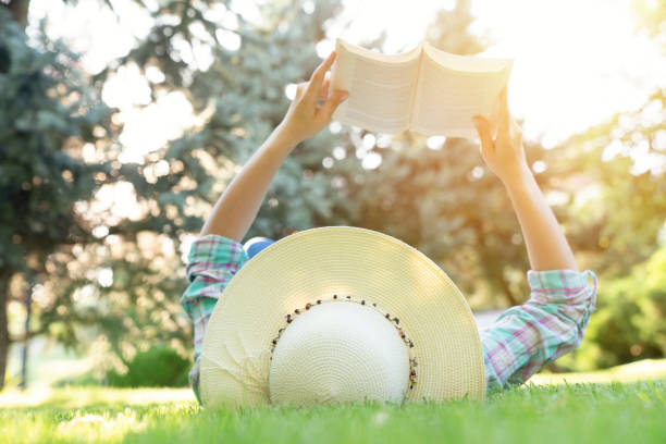 istock Young Girl Lying on Grass and Reading Book. 1263702172