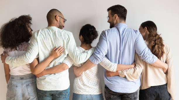 istock Rear view multiethnic best friends embracing standing near grey wall 1263705783