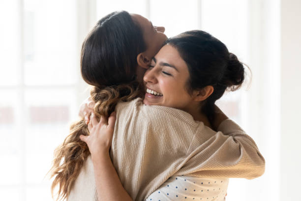 filles multiraciales candides meilleurs amis embrassant restant à l’intérieur - soeur photos et images de collection