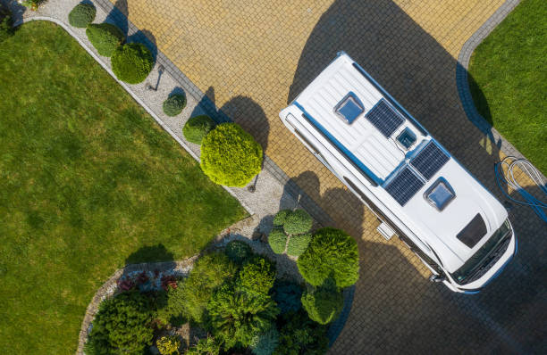 modern camper van with solar panels installed staying on residential driveway aerial view - rving imagens e fotografias de stock