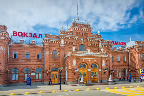 People stand in front of the Main Railway Station in Kazan, Republic of Tatarstan, Russia on a sunny day.