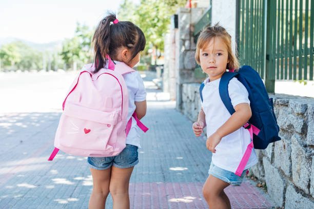 istock Two girls wearing backpack go to school. School concept. 1263716477