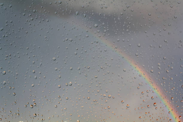 istock Window with raindrops with rainbow on the background 1263718106