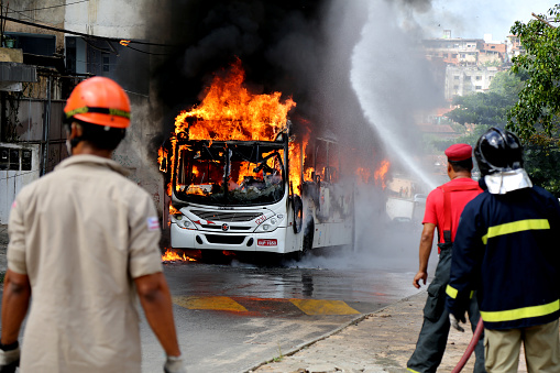 salvador, bahia / brazil - january 23, 2015: a member of the fire brigade extinguishes a fire in a public transport bus in the city of Salvador.