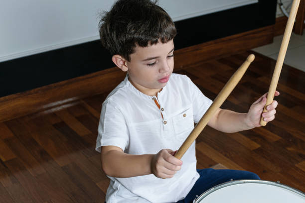 istock 7 year old child with his dumsticks ready to play the drums. 1263738519