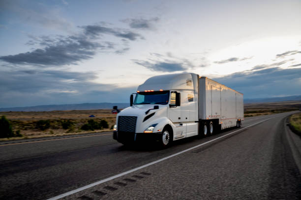 istock White Tractor, Semi-Trailer Freight Truck Rolling Down the Highway under a Dramatic Sky 1263740100