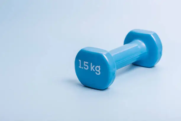 Photo of A pair of blue dumbbells on a blue background