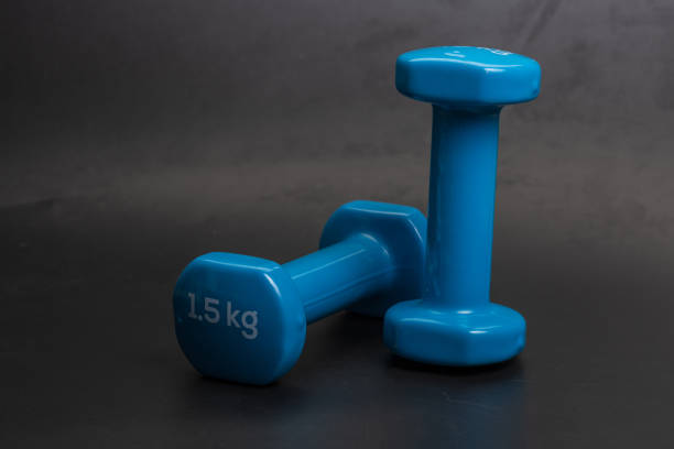 istock A pair of blue dumbbells on a black background 1263743071