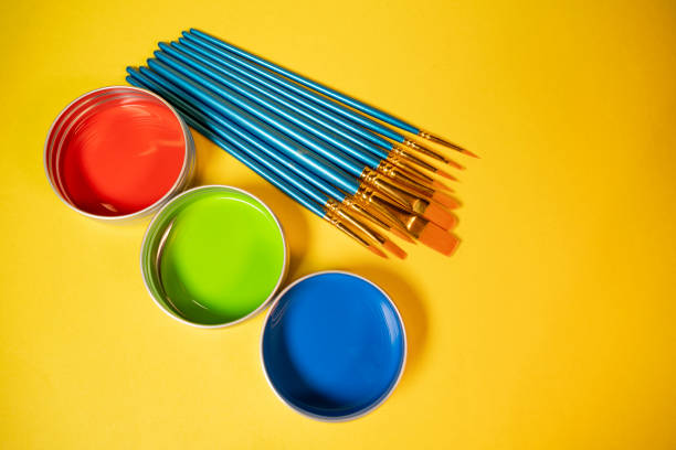 Primary colors in acrylic paint in metal tins still life art supply  and brushes