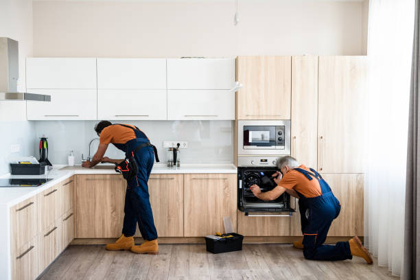 istock Pay and have it your way. Two handymen, workers in uniform fixing, installing furniture and equipment in the kitchen, using screwdriver indoors. Furniture repair and assembly concept 1263751393