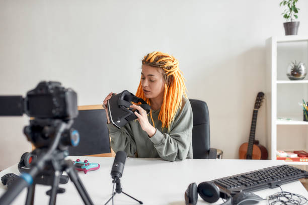istock Female technology blogger with dreadlocks holding, talking about vr glasses while recording video review of new gadgets at home 1263752788