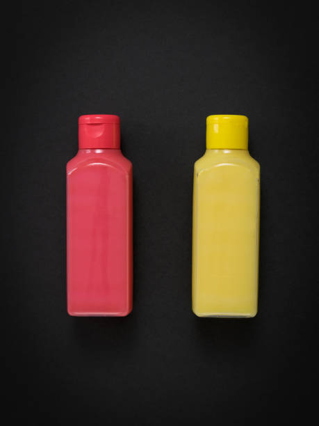 istock Pink and yellow plastic bottles on a black background. 1263752884