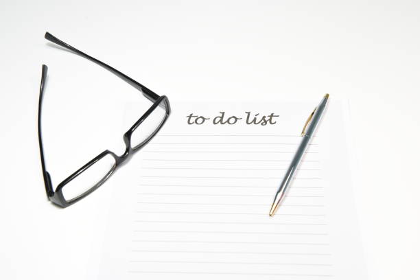 A white blank note or sheet of paper is on a wooden table background. To do list concept with no plans.