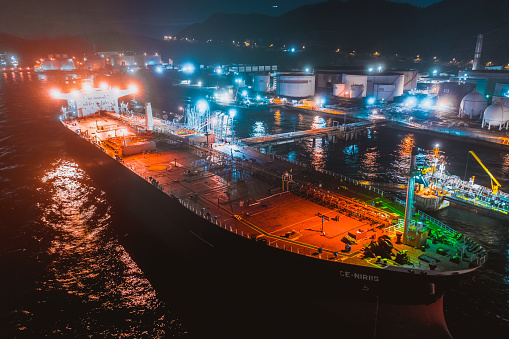 oil tanker and oil tank in port at night