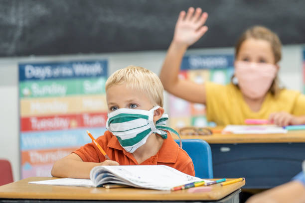 istock Young student wearing a protective face mask in the classroom 1263760315