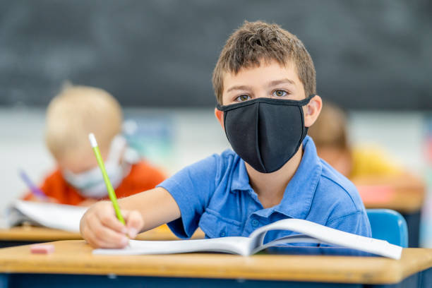 istock Young student wearing a protective face mask in the classroom 1263760316